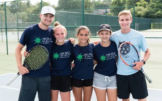 a group of kids holding tennis rackets