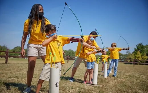 a group of kids shooting bows