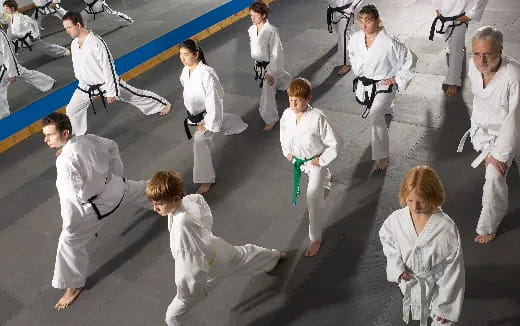a group of people in white karate uniforms