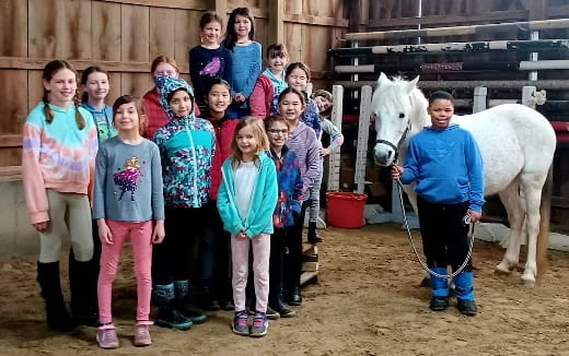 a group of people posing for a photo with a horse