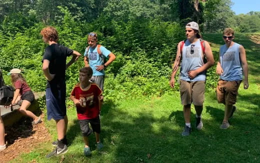 a group of people walking on a grassy hill