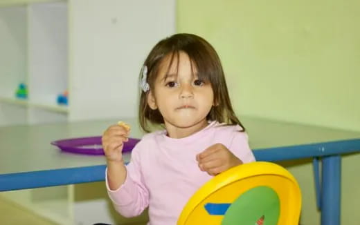 a little girl holding a toy