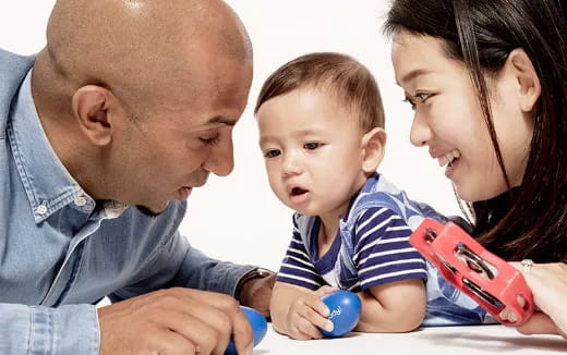 a man and woman holding a baby