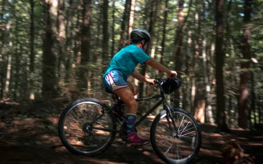 a man riding a bike in the woods