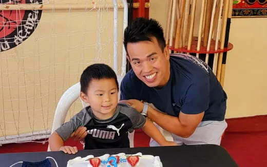 a person and a boy sitting at a table with food