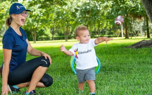 a person and a child playing in the grass