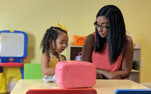 a person and a child playing with a toy
