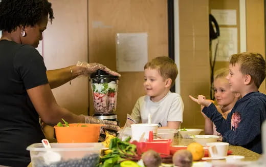 a person and kids eating at a table