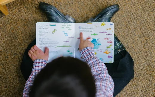 a person lying on the floor reading a book