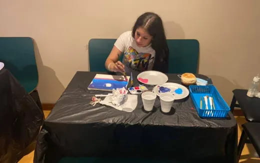 a person sitting at a table with food and drinks