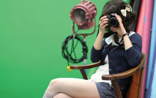 a person sitting in a chair holding a camera