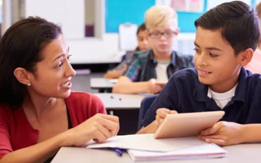 a woman and a boy looking at a book