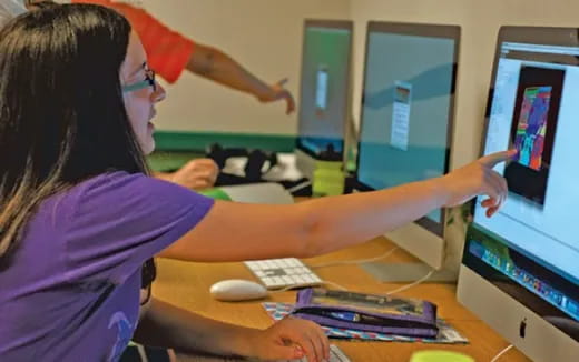 a woman showing a man something on the computer