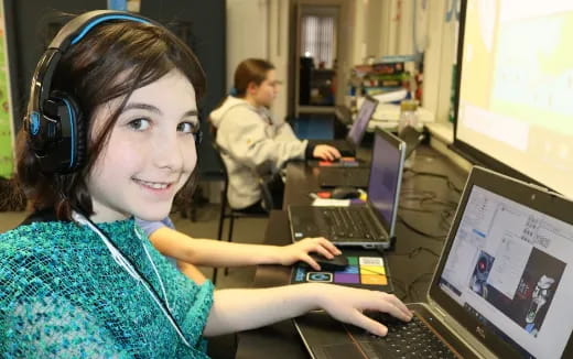 a woman wearing headphones and using a laptop
