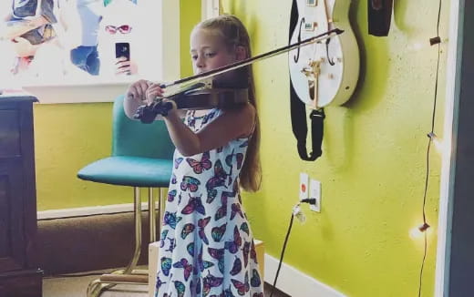 a young girl playing a violin