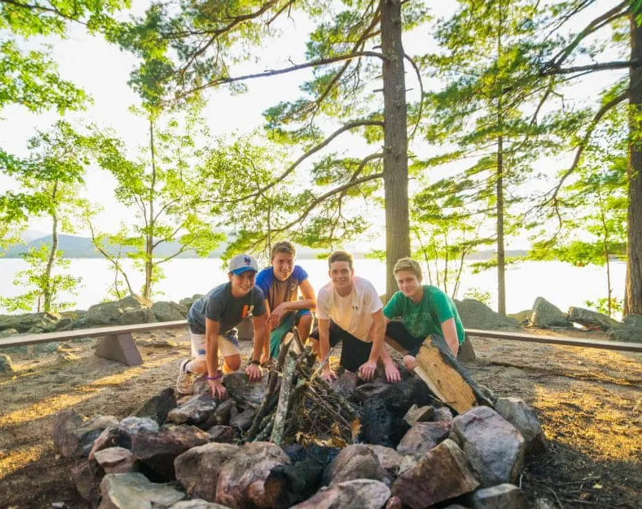 a group of people sitting on rocks by the water