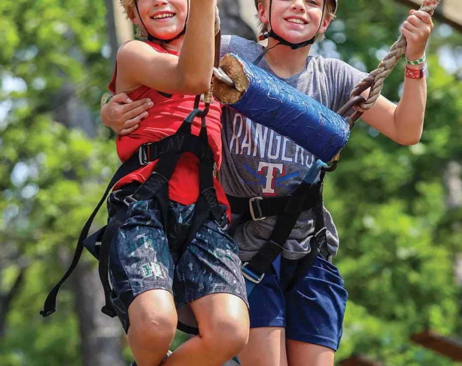 a person and a boy on a zip line