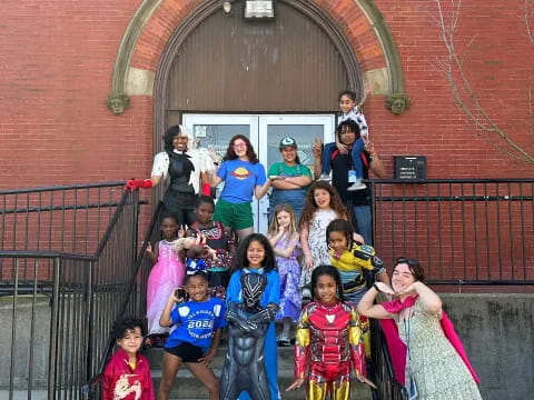 a group of people posing for a photo in front of a brick building