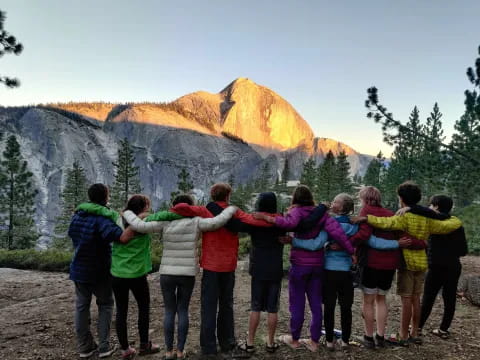 a group of people posing for a photo in front of a mountain