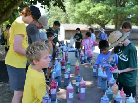 a group of people standing around a table with bottles of water