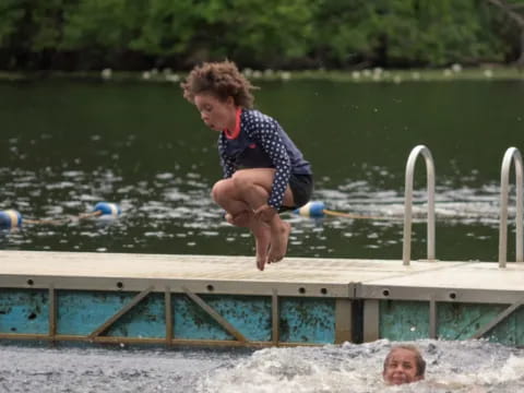 a boy jumping into a pool