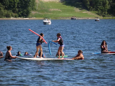 a group of people paddle surfboards