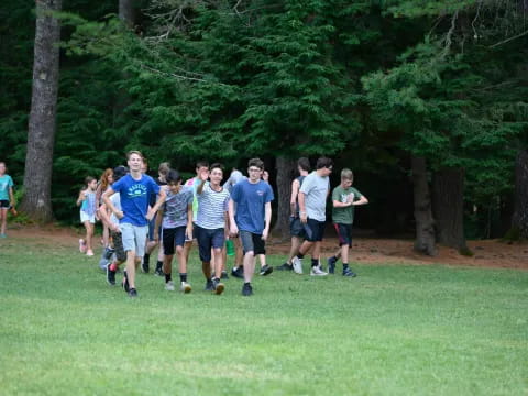 a group of people running on a grass field