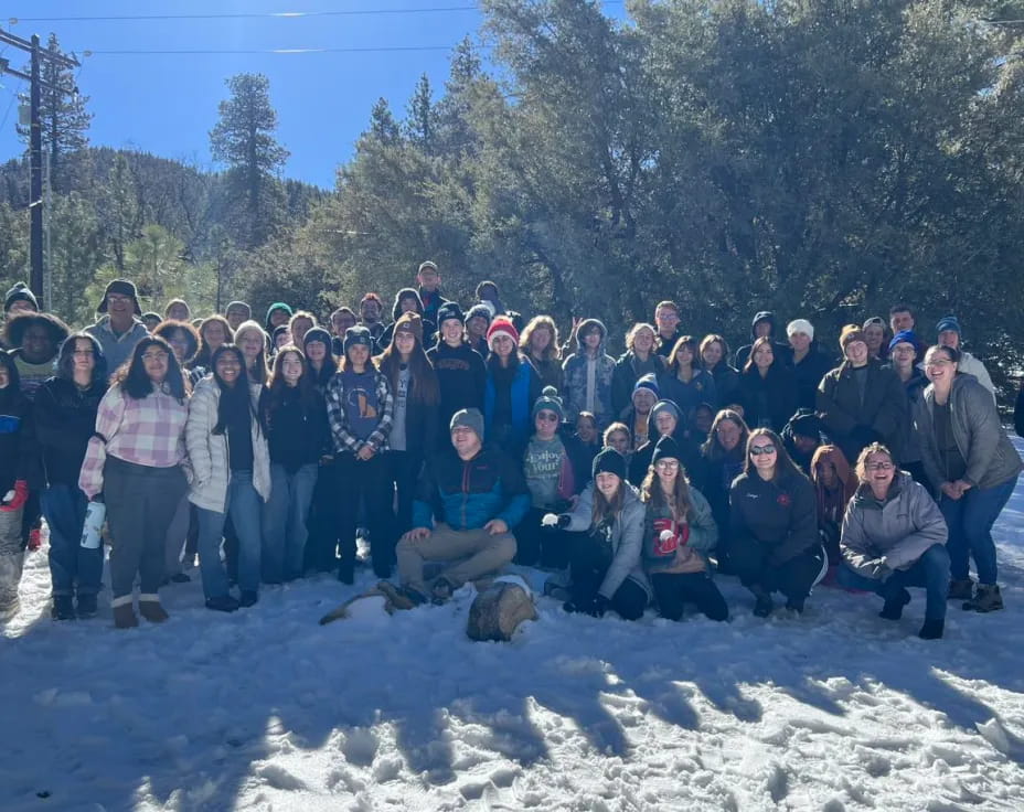 a group of people posing for a photo in the snow