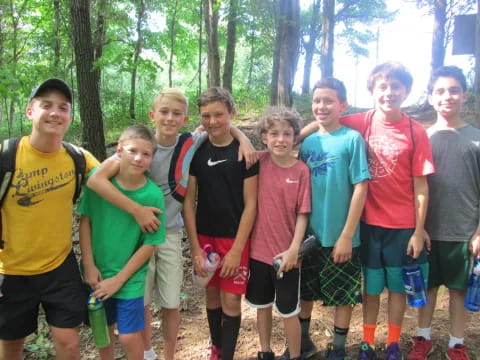 a group of people posing for a photo in the woods