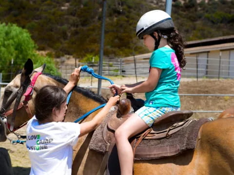 a girl riding a horse with a girl on the back