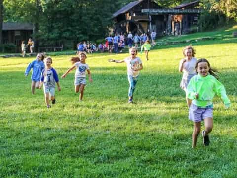 a group of children running on a grass field