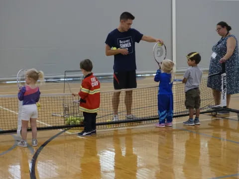 a person and kids playing tennis