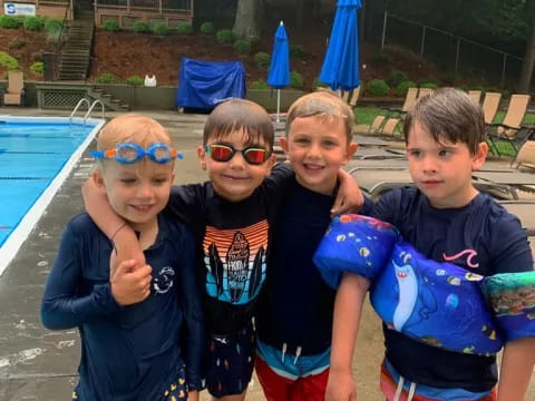 a group of boys posing for a picture next to a pool