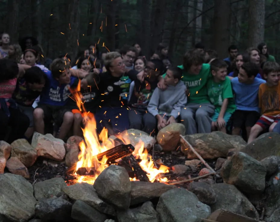 a group of people sitting around a fire