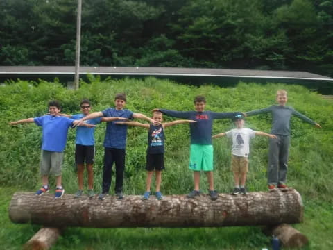 a group of people posing for a photo on a log