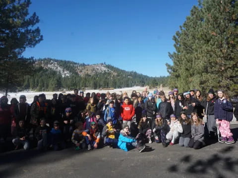 a group of people posing for a photo next to a body of water