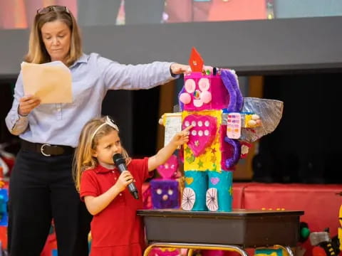 a person and a girl holding a microphone and a box