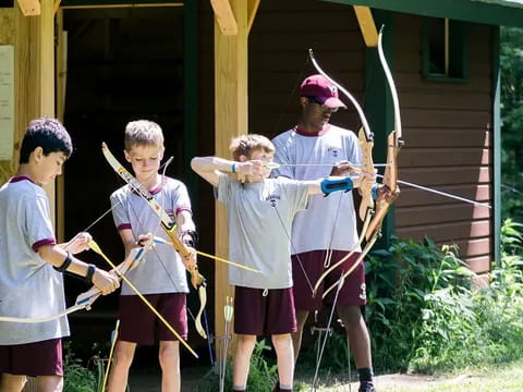 a group of boys holding bows and arrows