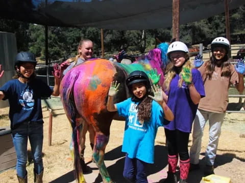 a group of people posing with a person in a horse garment