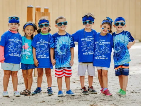 a group of children wearing blue and white shirts and blue bandanas