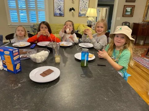 a group of kids eating at a table