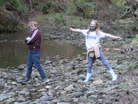 a couple of people posing for the camera by a river