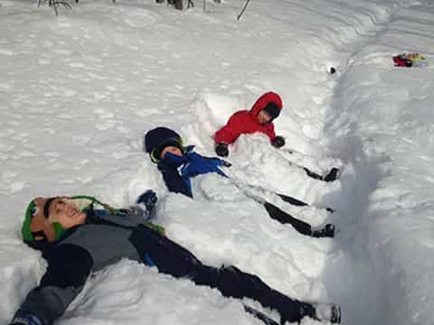 a group of kids playing in the snow