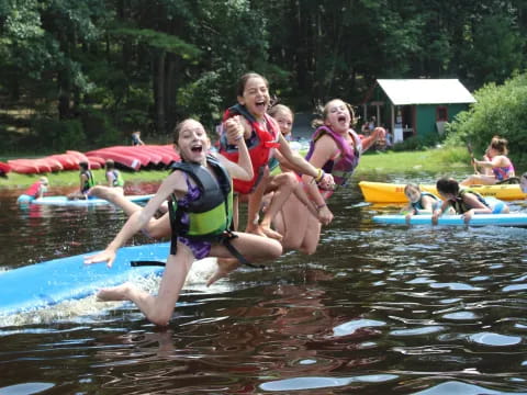a group of girls in life jackets in a pool
