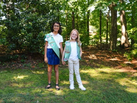 two women standing in a grassy area