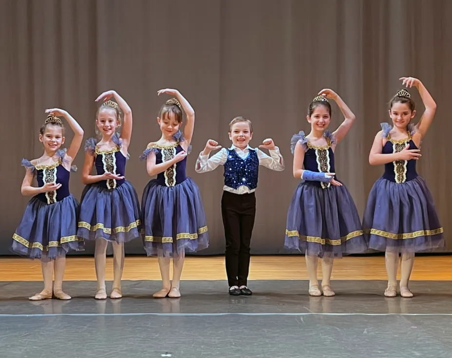 a group of children in blue and yellow dresses on a stage