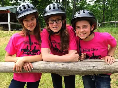 a group of girls wearing helmets and posing for a photo