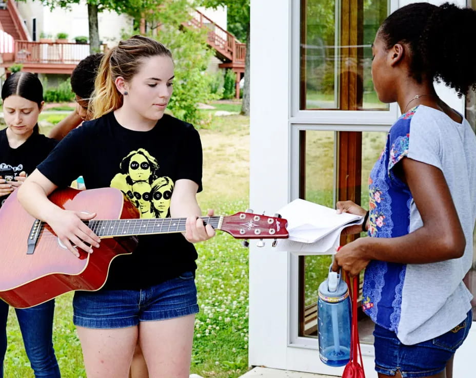 a group of girls playing a guitar