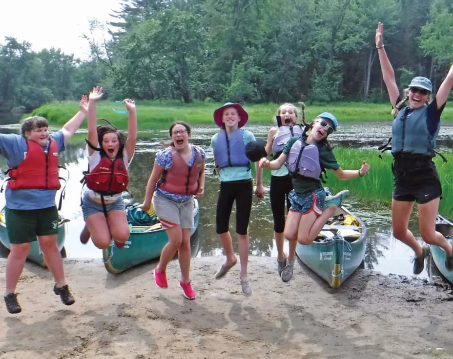 a group of people posing for a photo next to some boats