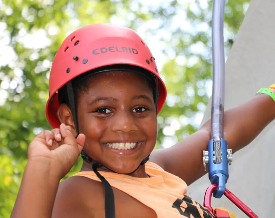 a young girl wearing a helmet and holding a pole